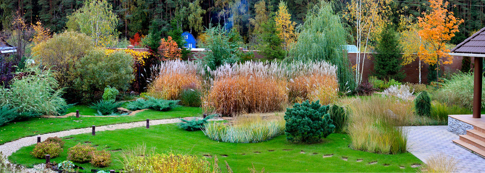 This is an example of a mid-sized contemporary partial sun courtyard gravel landscaping in Moscow for fall.