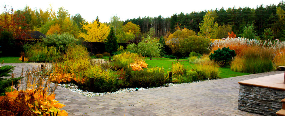 Exemple d'un jardin scandinave de taille moyenne et au printemps avec une exposition ensoleillée, du gravier et un massif de fleurs.