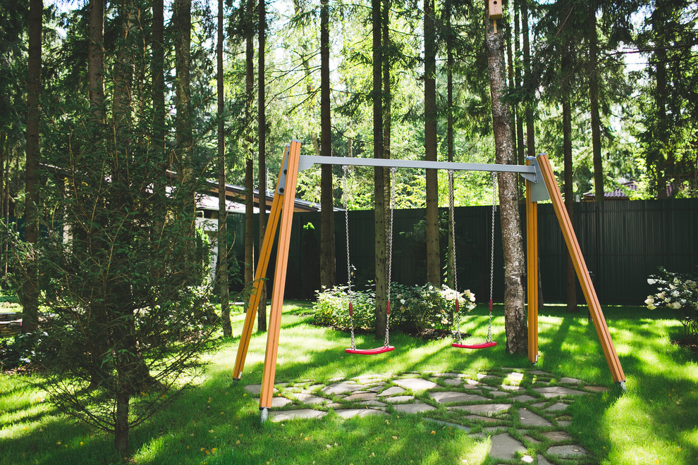 Aménagement d'un aire de jeux d'extérieur contemporain l'été avec une exposition partiellement ombragée.