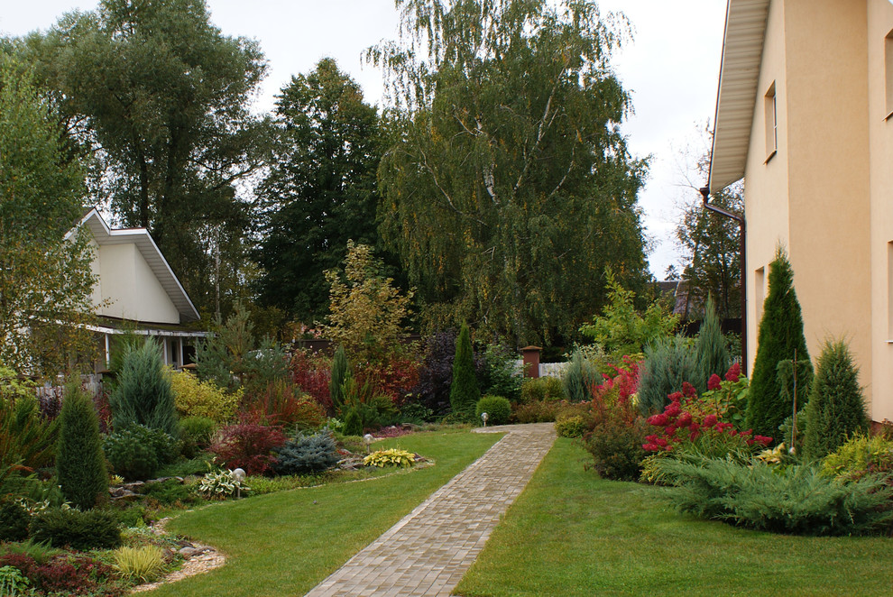 Пример оригинального дизайна: солнечный, осенний участок и сад среднего размера на боковом дворе в современном стиле с хорошей освещенностью и мощением тротуарной плиткой