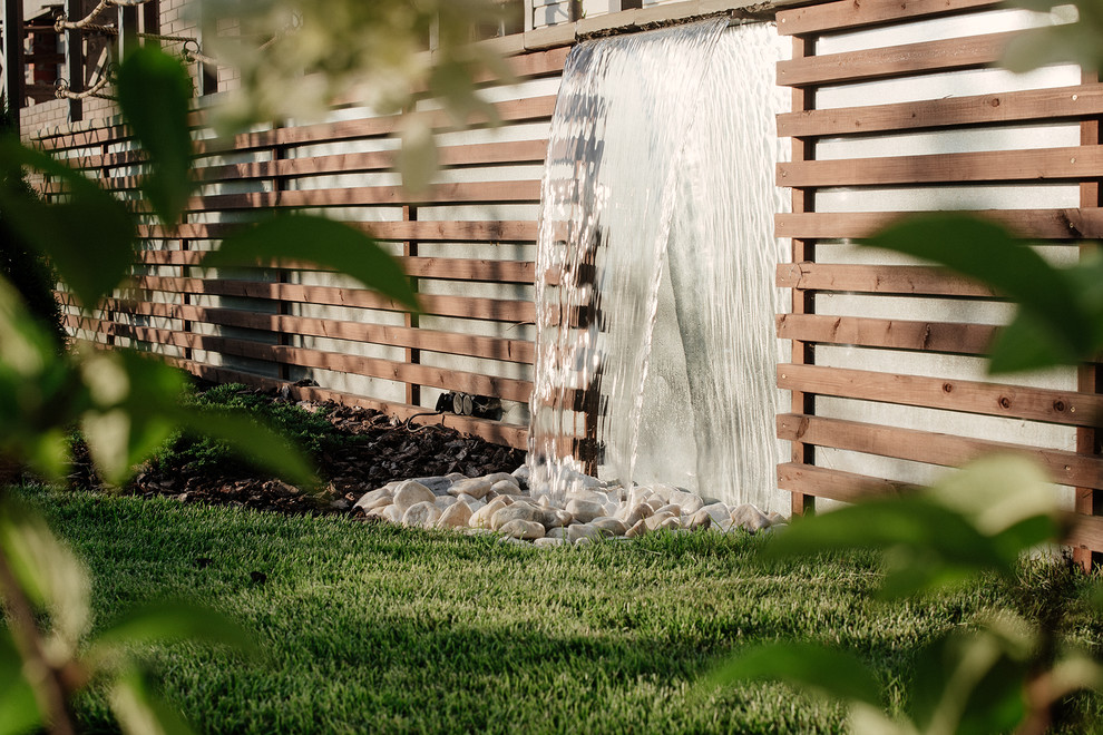 Contemporary garden for summer in Other with a water feature.