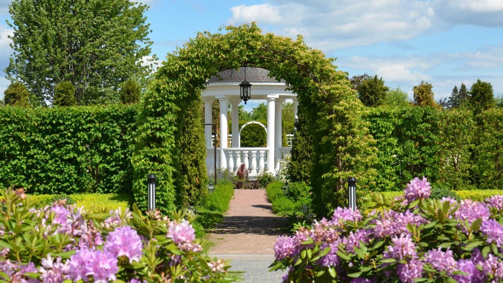 На фото: солнечный, летний регулярный сад на внутреннем дворе в классическом стиле с хорошей освещенностью и с перголой с