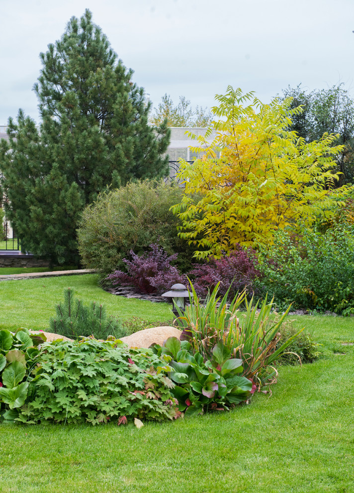 Esempio di un giardino esposto in pieno sole davanti casa in autunno con un muro di contenimento