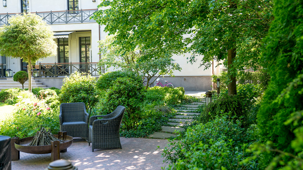 Imagen de jardín clásico de tamaño medio en verano en patio con exposición parcial al sol, adoquines de piedra natural y jardín francés