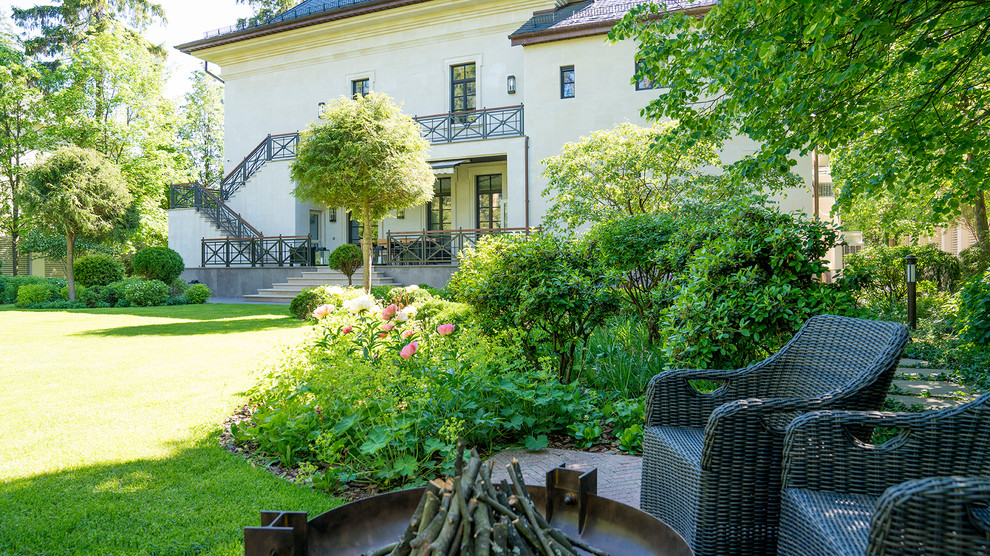 This is an example of a mid-sized traditional partial sun courtyard stone formal garden in Moscow with a fire pit for summer.