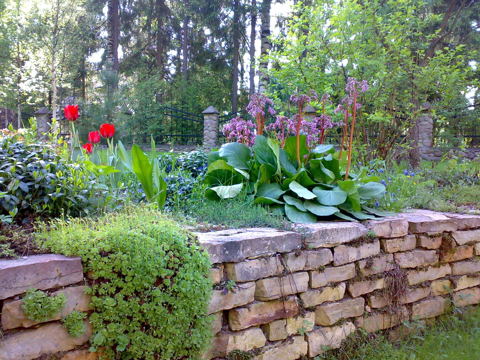 Idées déco pour un grand jardin latéral classique au printemps avec un mur de soutènement, une exposition partiellement ombragée et des pavés en béton.