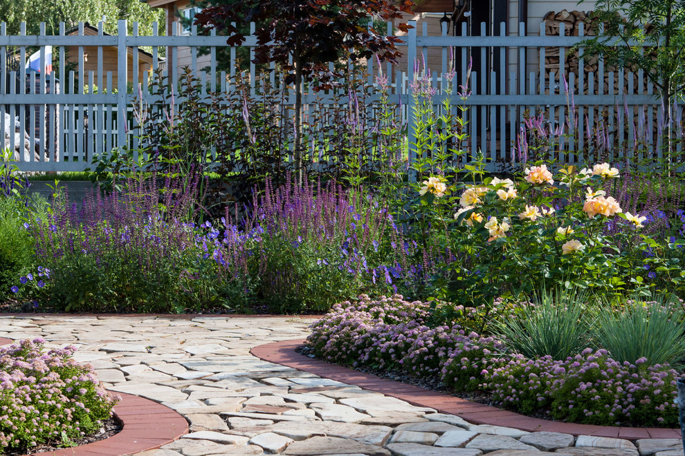 Immagine di un giardino tradizionale esposto in pieno sole di medie dimensioni e davanti casa in estate con pavimentazioni in pietra naturale