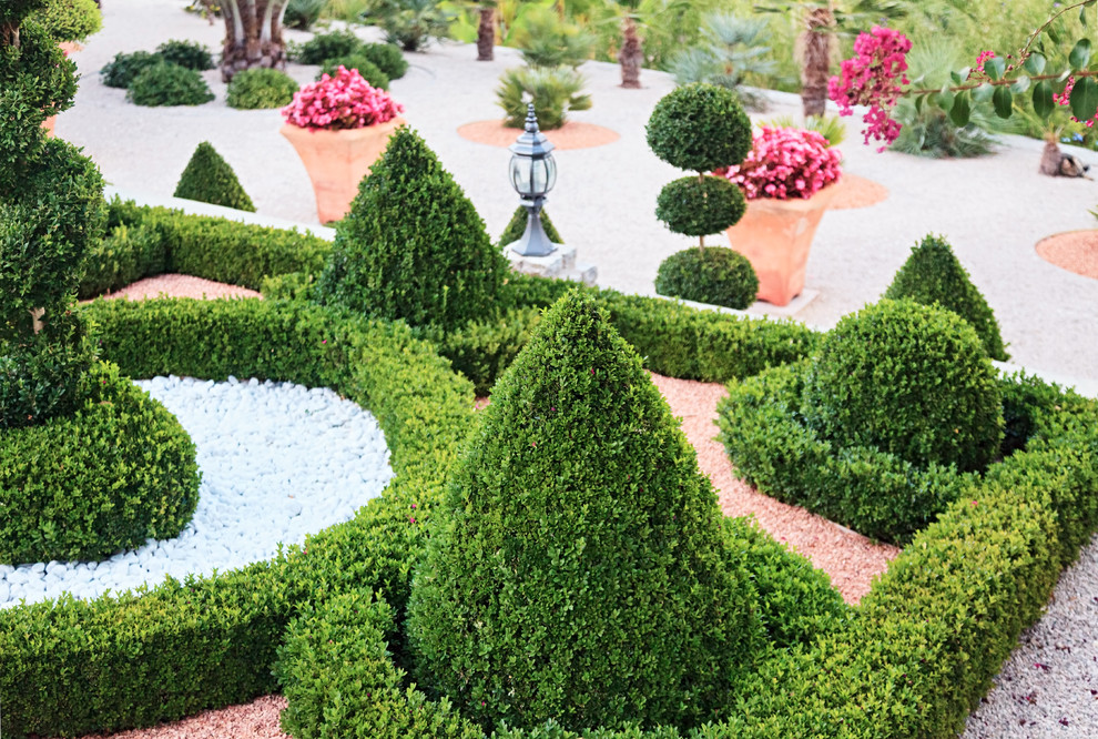 На фото: солнечный, летний регулярный сад в классическом стиле с хорошей освещенностью и покрытием из гравия