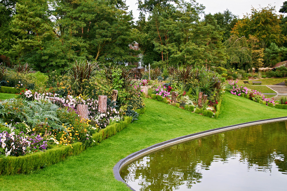 На фото: солнечный, летний сад с прудом в современном стиле с хорошей освещенностью с