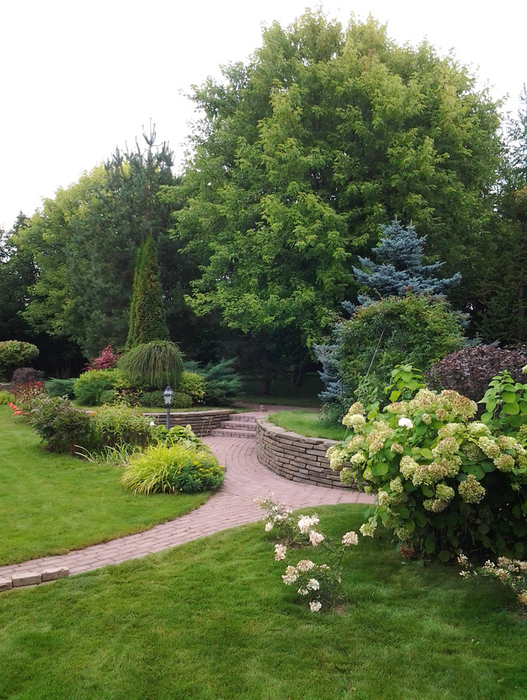 Foto di un giardino classico esposto a mezz'ombra in estate con un muro di contenimento