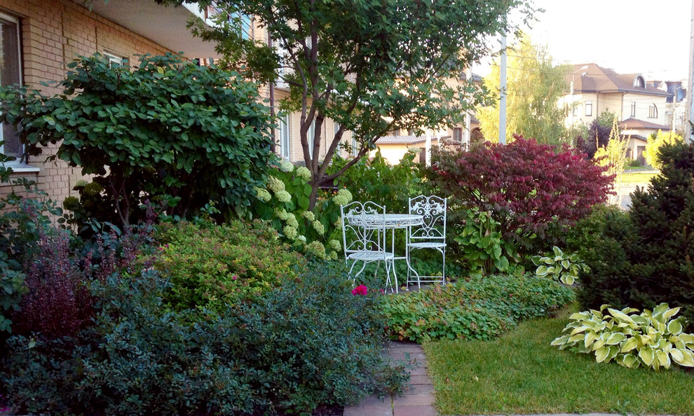Inspiration för en liten vintage trädgård i delvis sol framför huset på hösten, med en trädgårdsgång och naturstensplattor