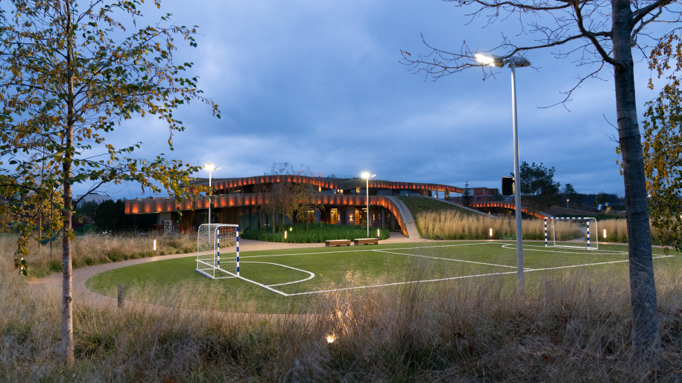 На фото: огромная солнечная, осенняя спортивная площадка на внутреннем дворе в стиле модернизм с хорошей освещенностью с