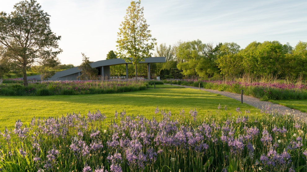 Réalisation d'un très grand jardin sur cour minimaliste au printemps avec une exposition ensoleillée et du gravier.