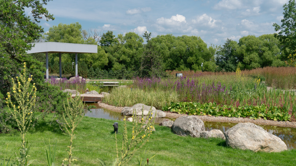 На фото: огромный солнечный, летний участок и сад на внутреннем дворе в стиле модернизм с хорошей освещенностью, покрытием из гравия и камнем в ландшафтном дизайне