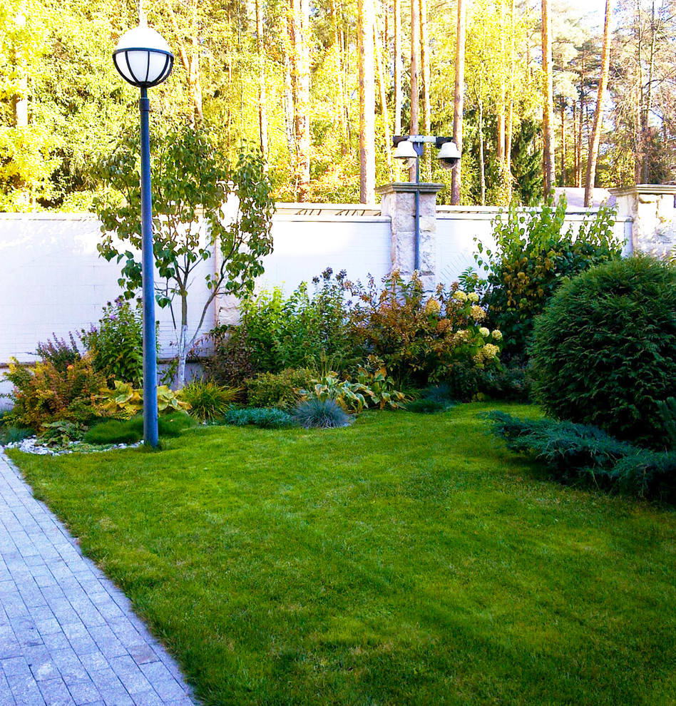 Photo of an expansive classic front driveway full sun garden for autumn in Moscow with natural stone paving and a flowerbed.