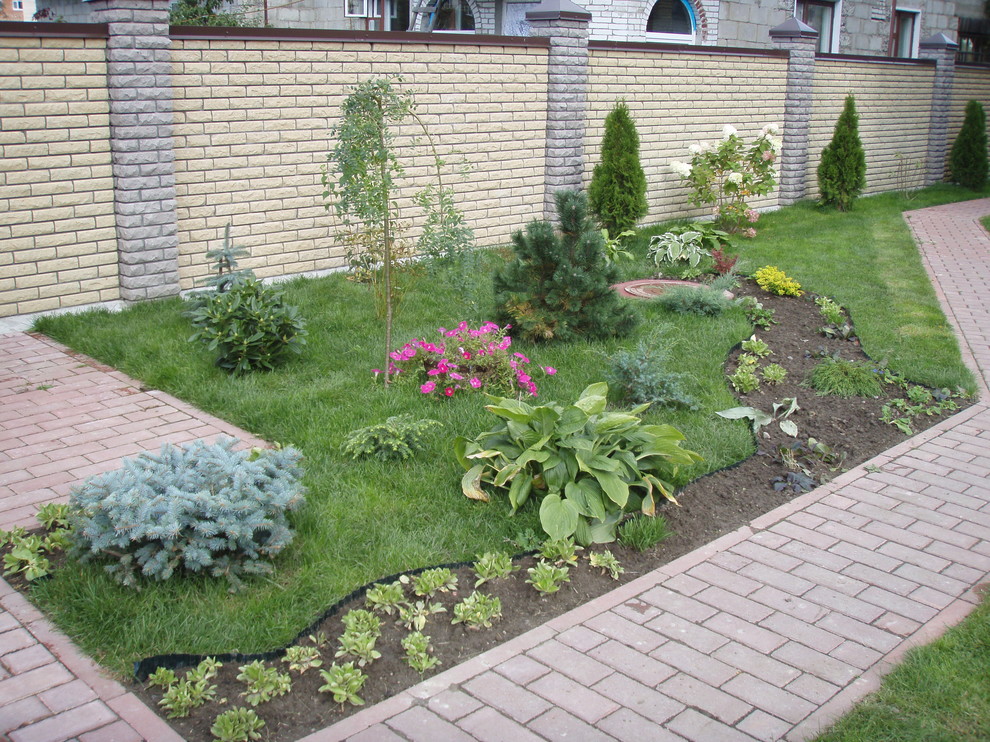 Inspiration för mellanstora klassiska trädgårdar i delvis sol på sommaren, med en trädgårdsgång och marksten i betong
