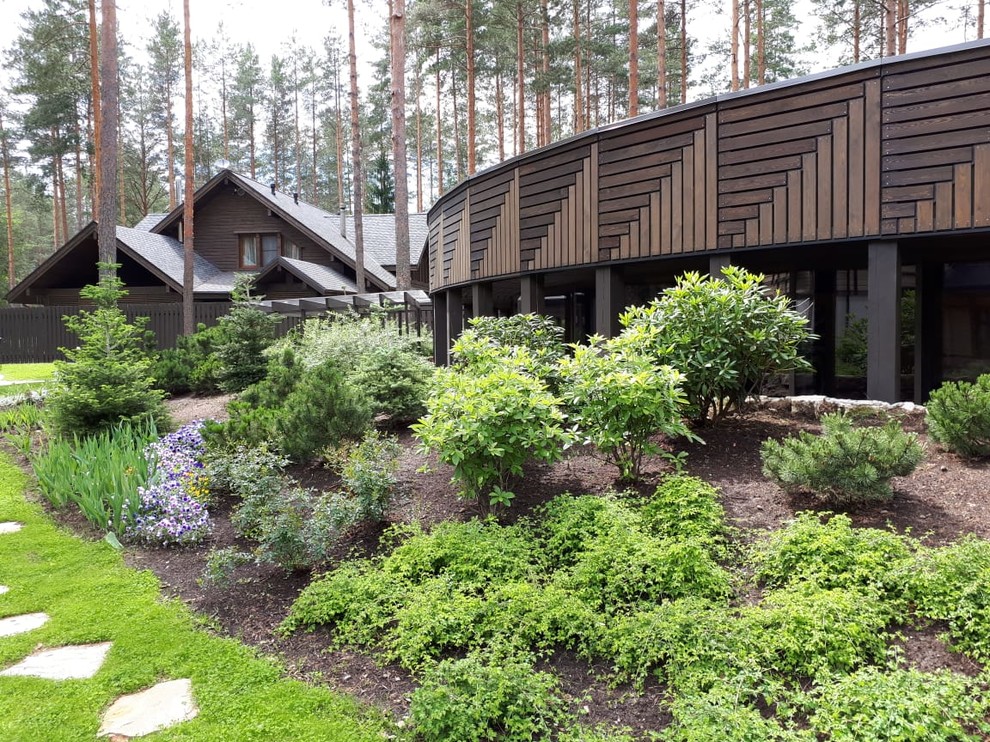 Idée de décoration pour un jardin nordique l'été avec une exposition partiellement ombragée et des pavés en pierre naturelle.