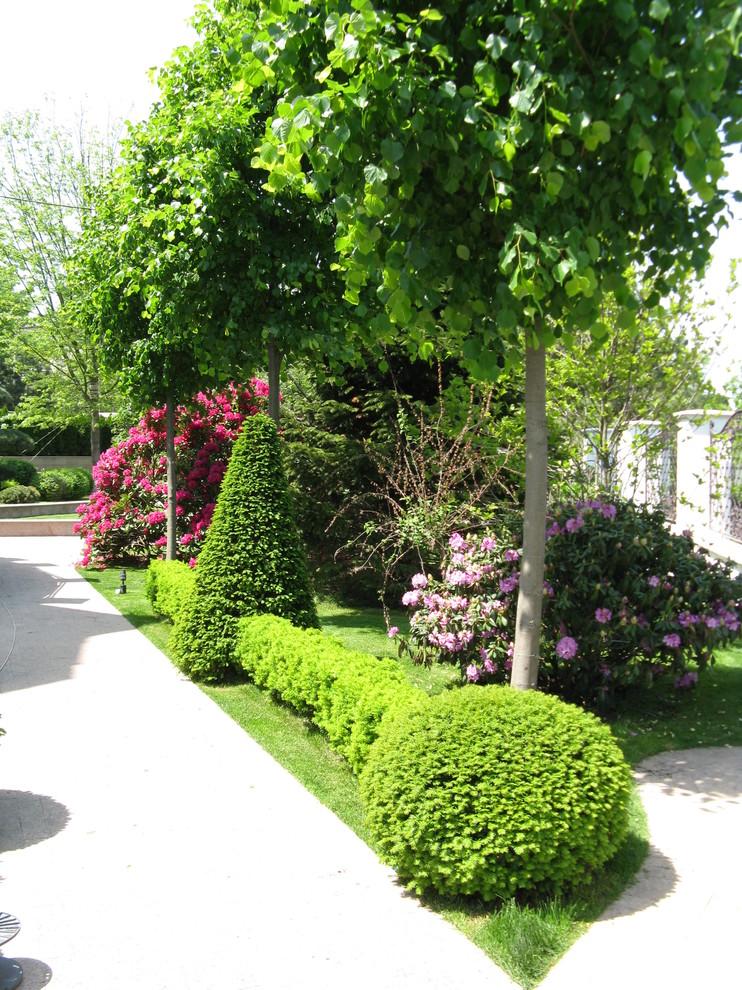 Ejemplo de jardín tradicional en verano con jardín francés y exposición total al sol