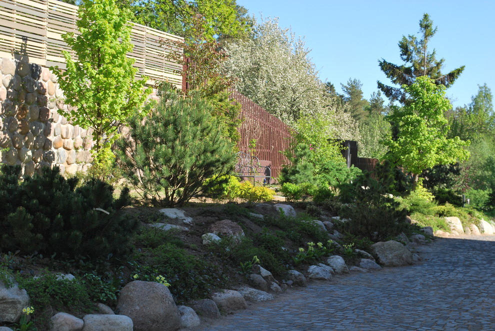 Immagine di un grande giardino classico esposto in pieno sole in cortile in primavera con pavimentazioni in pietra naturale