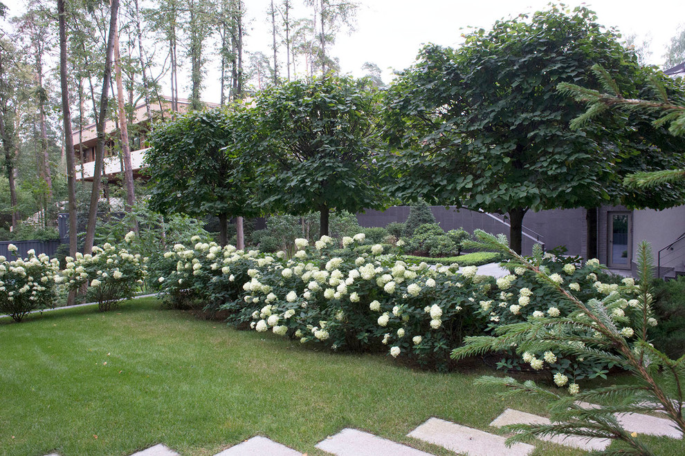 На фото: большой летний участок и сад на внутреннем дворе в стиле модернизм с полуденной тенью с