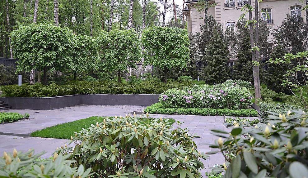 На фото: большой весенний участок и сад на внутреннем дворе в стиле модернизм с полуденной тенью и покрытием из каменной брусчатки