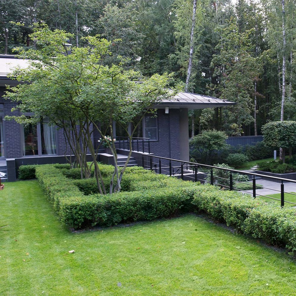Immagine di un giardino formale minimalista esposto a mezz'ombra in cortile e di medie dimensioni in estate con pavimentazioni in pietra naturale
