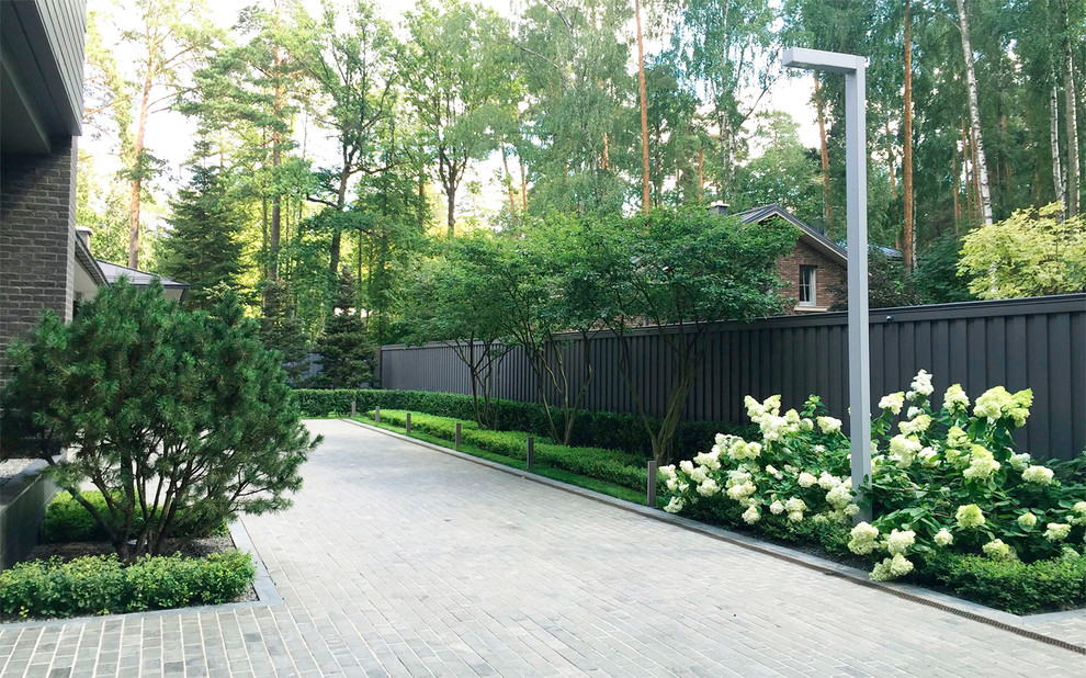 Идея дизайна: летний регулярный сад на переднем дворе в стиле неоклассика (современная классика) с полуденной тенью и покрытием из каменной брусчатки
