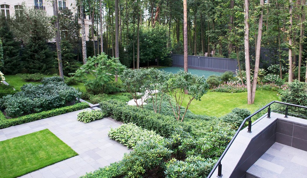 Design ideas for a large modern courtyard formal partial sun garden for summer in Moscow with natural stone paving.