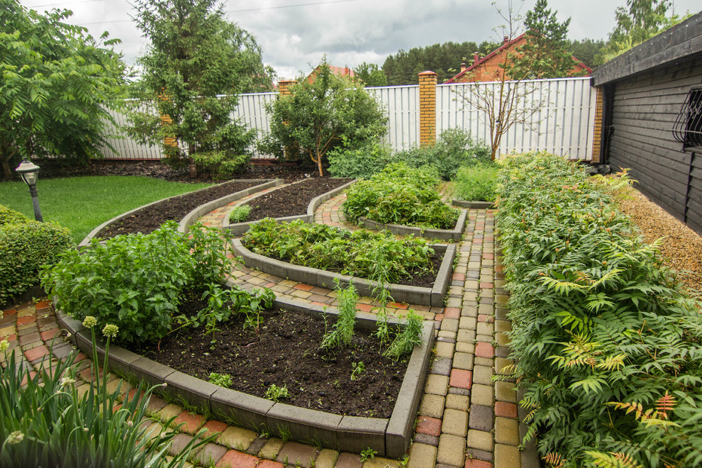 На фото: летний регулярный сад на боковом дворе в современном стиле