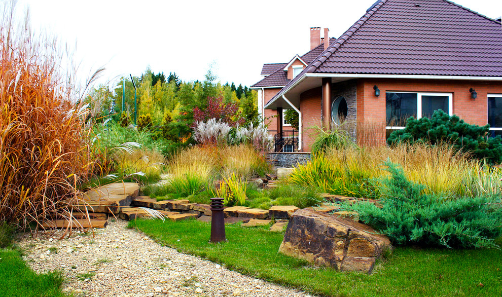 Foto di un giardino xeriscape chic esposto in pieno sole di medie dimensioni e in cortile in autunno con ghiaia e sassi e rocce