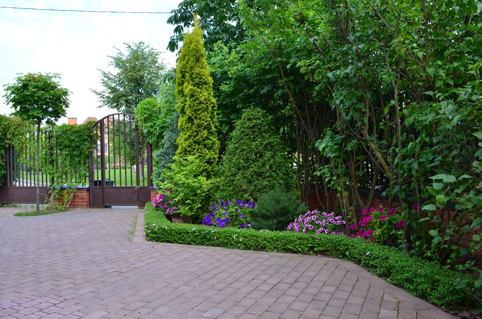 На фото: летний регулярный сад в классическом стиле с садовой дорожкой или калиткой и мощением клинкерной брусчаткой