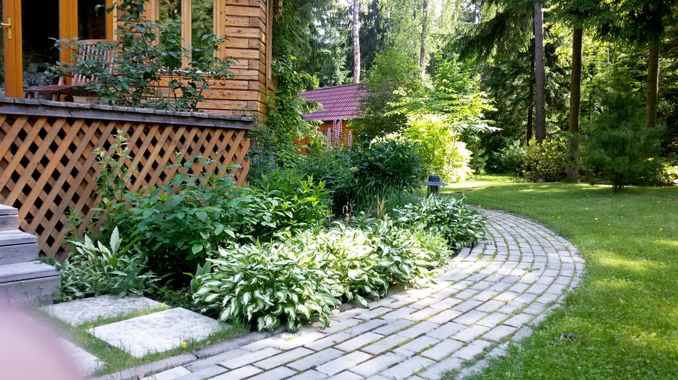 Imagen de camino de jardín tradicional grande en verano en patio delantero con exposición total al sol y adoquines de hormigón