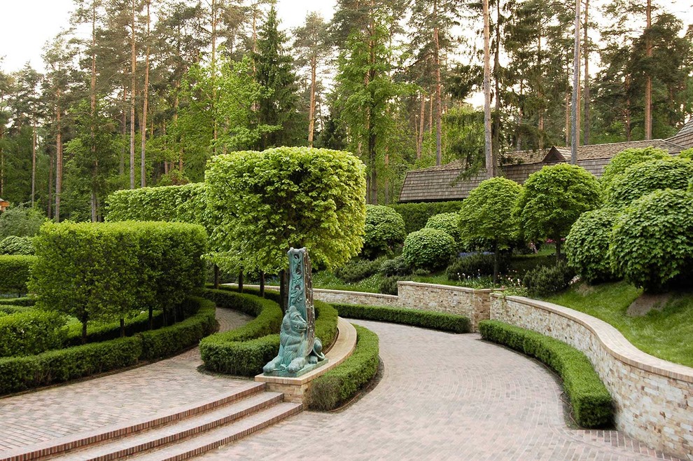 Imagen de jardín clásico en verano con jardín francés, muro de contención y exposición parcial al sol