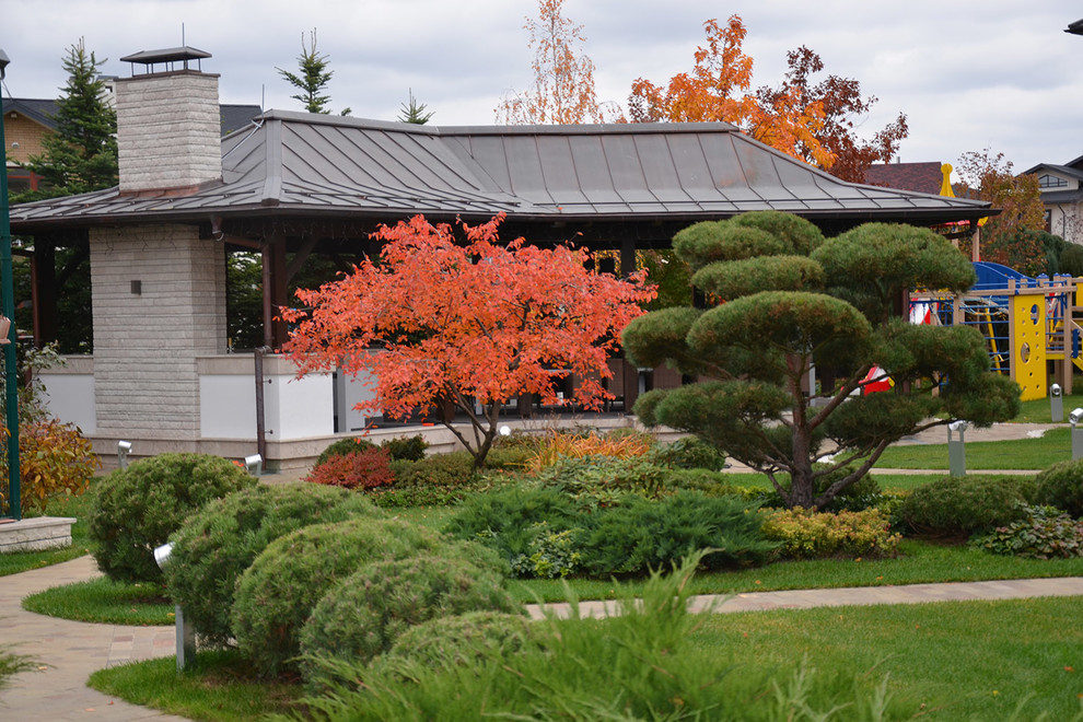 Foto de jardín minimalista de tamaño medio en otoño en patio con exposición total al sol y adoquines de piedra natural