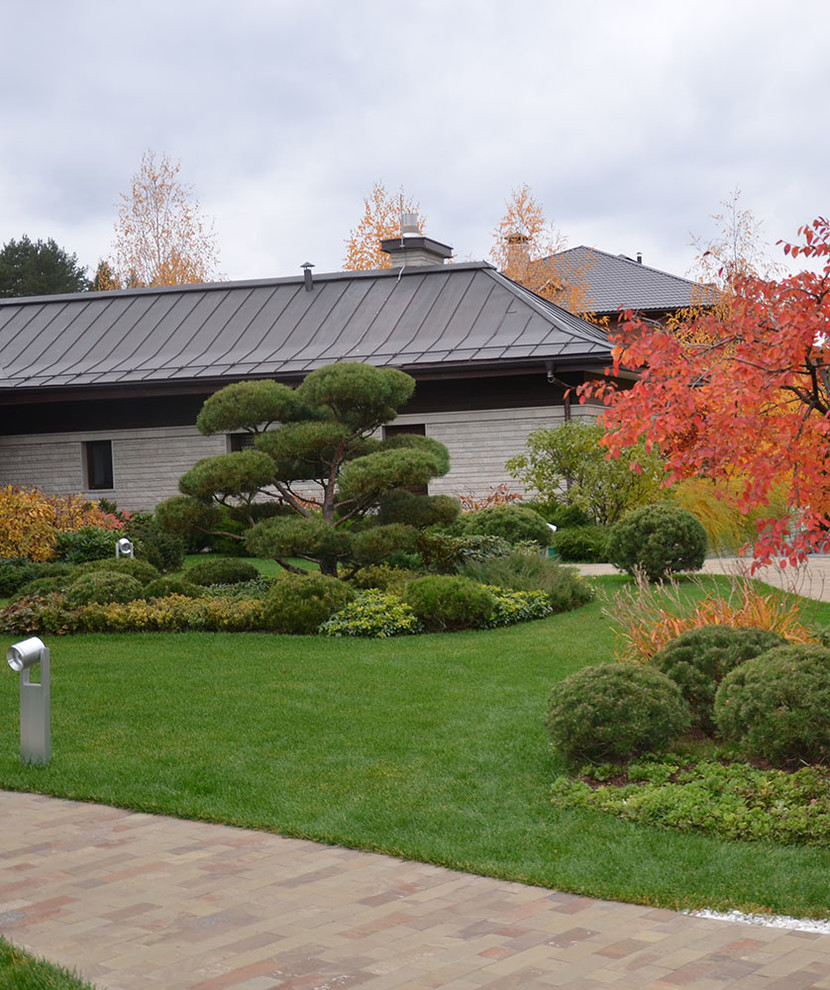 Ejemplo de jardín moderno de tamaño medio en otoño en patio con exposición total al sol y adoquines de piedra natural