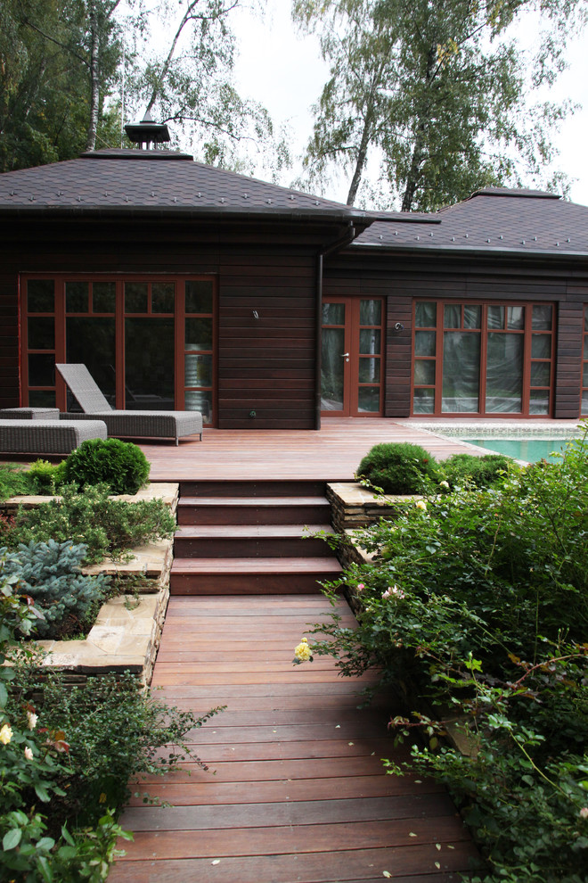 Photo of a medium sized contemporary courtyard partial sun garden for summer in Moscow with a retaining wall and decking.