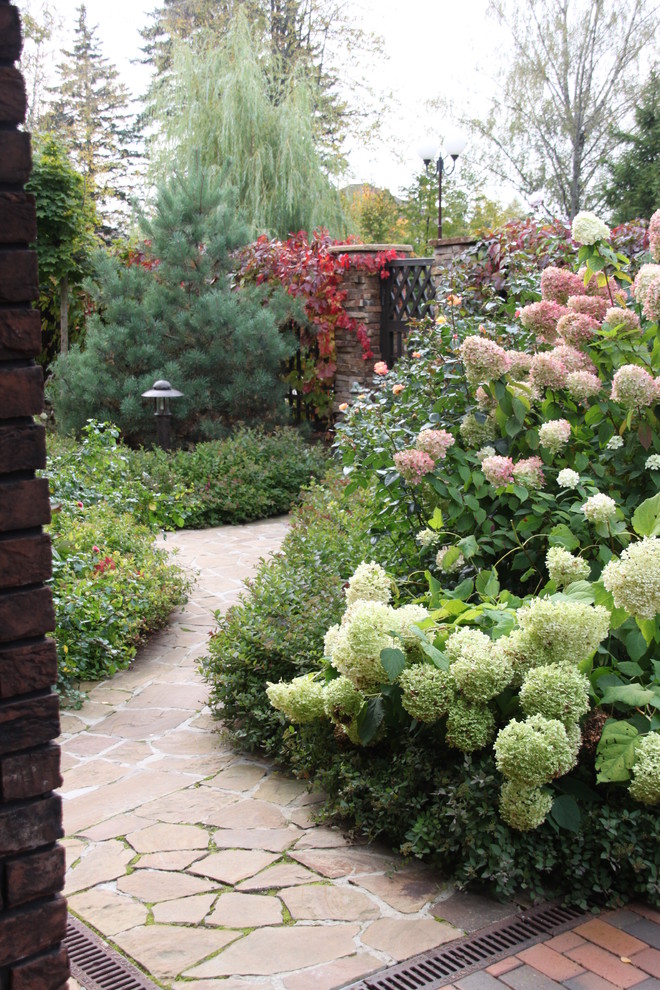Пример оригинального дизайна: летний регулярный сад на переднем дворе в классическом стиле с садовой дорожкой или калиткой, полуденной тенью и покрытием из каменной брусчатки