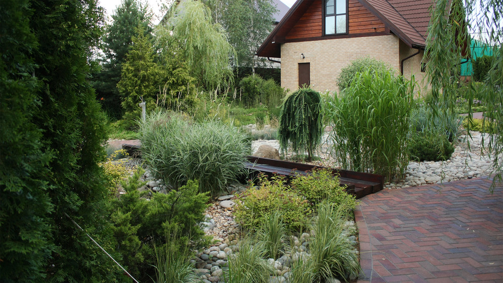 Inspiration pour un jardin traditionnel de taille moyenne et l'été avec une exposition partiellement ombragée et des pavés en brique.