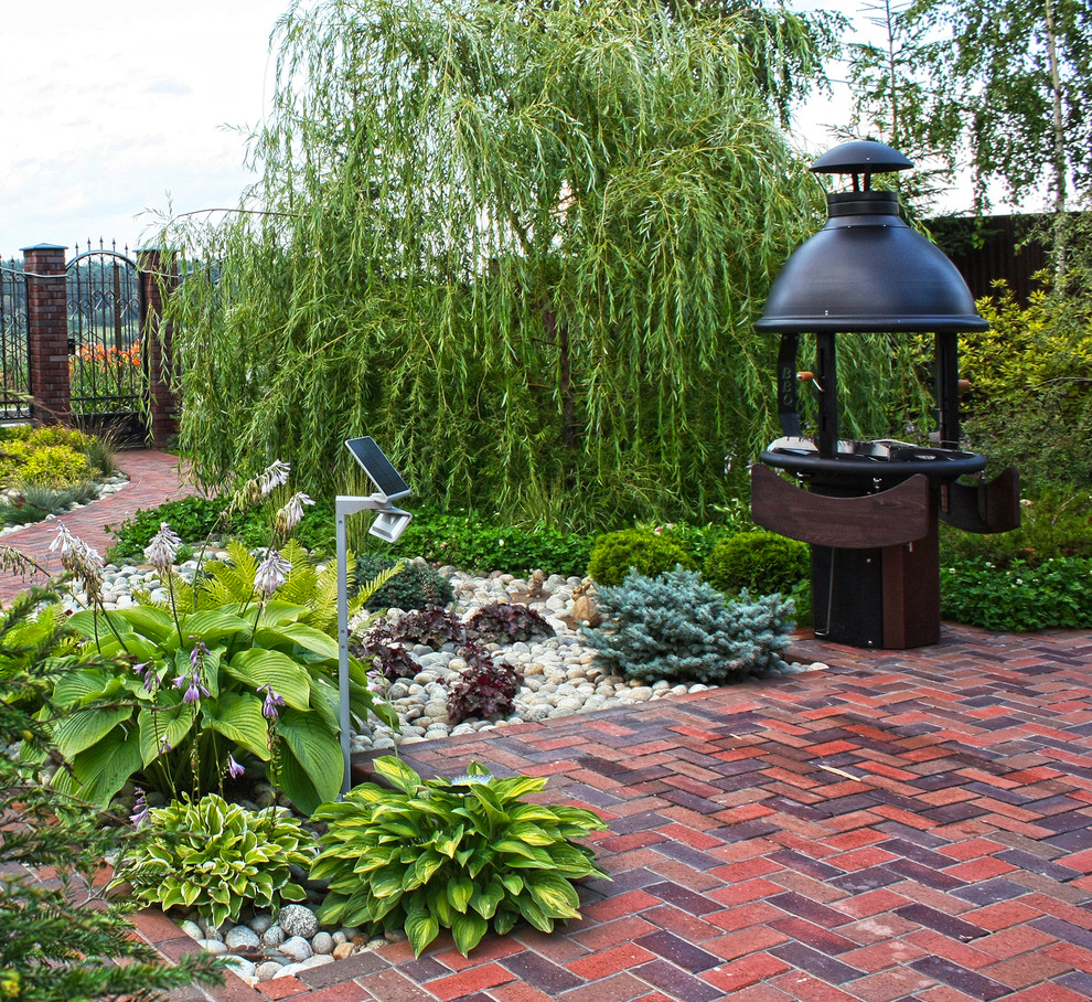 This is an example of a medium sized contemporary courtyard full sun garden for spring in Moscow with brick paving.