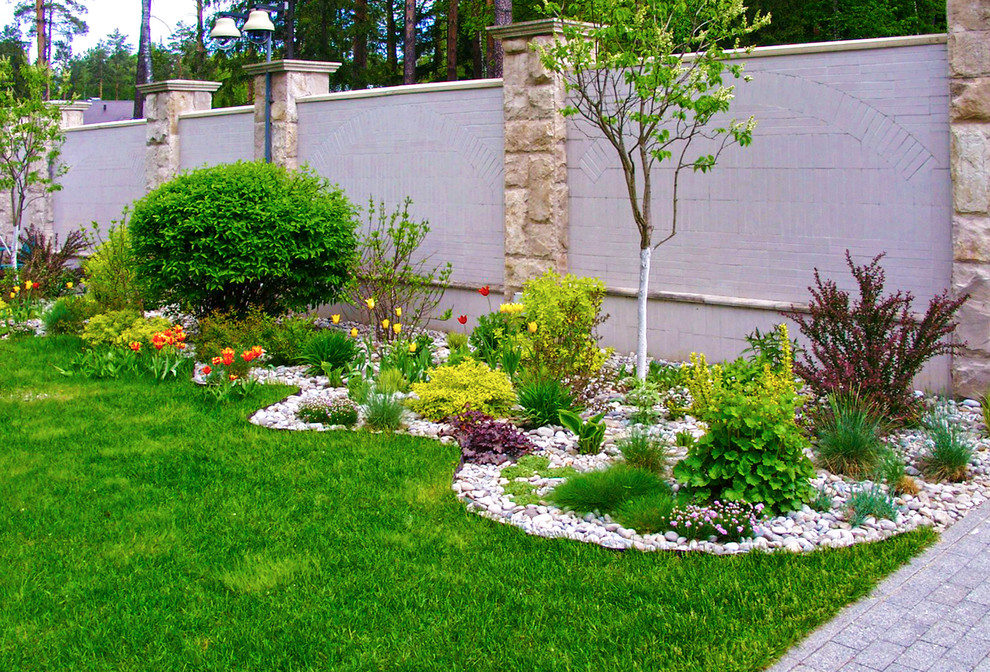 Foto di un grande giardino tradizionale esposto in pieno sole davanti casa in primavera con pavimentazioni in pietra naturale