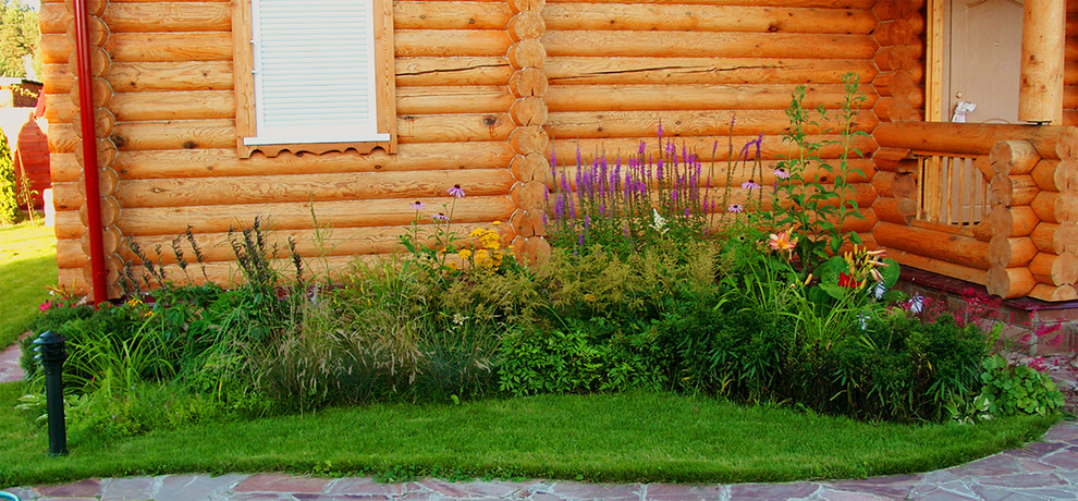 Immagine di un'aiuola country esposta in pieno sole di medie dimensioni e in cortile in estate con pavimentazioni in pietra naturale