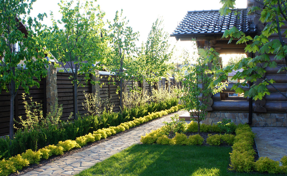 Свежая идея для дизайна: большой летний участок и сад в современном стиле с забором - отличное фото интерьера