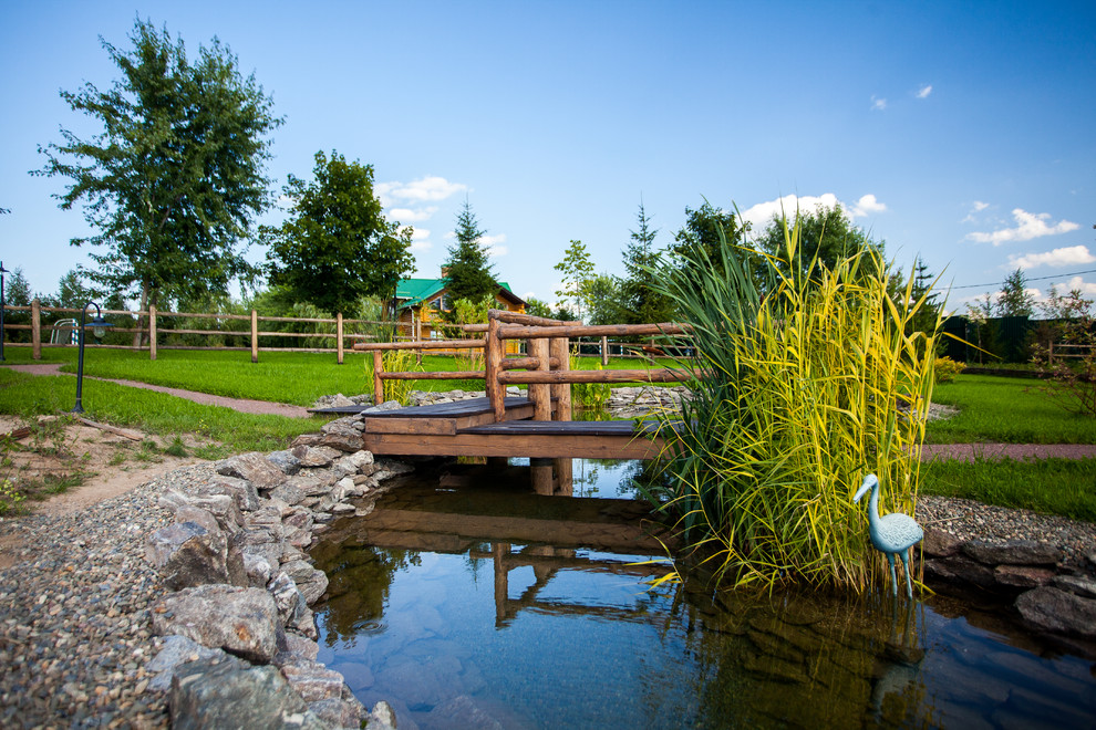 Immagine di un giardino formale country esposto in pieno sole in estate con fontane e un pendio, una collina o una riva