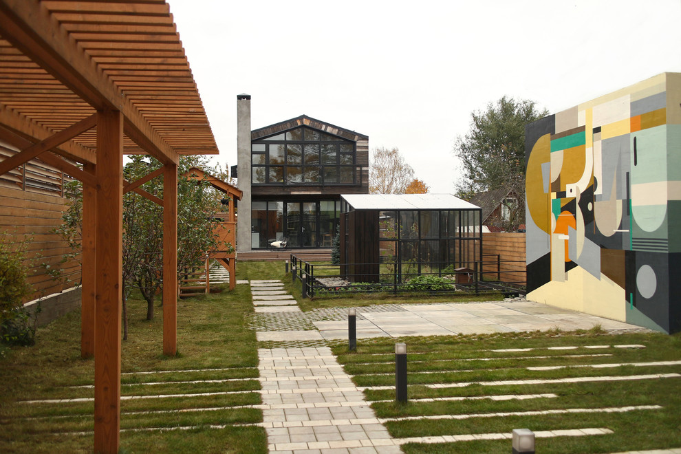 Diseño de jardín contemporáneo pequeño en otoño en patio delantero con parque infantil, adoquines de hormigón y exposición parcial al sol