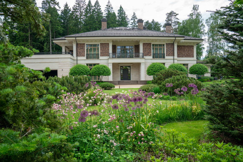 Idee per un grande giardino classico esposto in pieno sole davanti casa in primavera con pavimentazioni in cemento