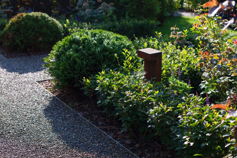 Ejemplo de jardín clásico en verano con exposición parcial al sol y gravilla