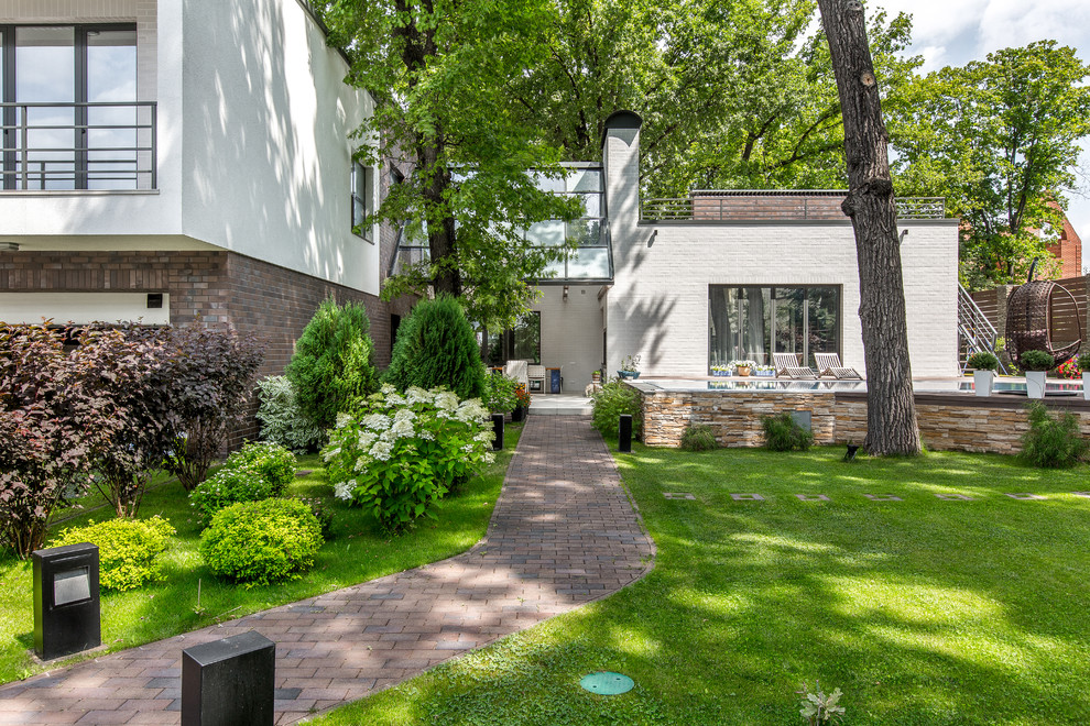 Esempio di un grande giardino formale classico esposto a mezz'ombra davanti casa in estate con pavimentazioni in mattoni