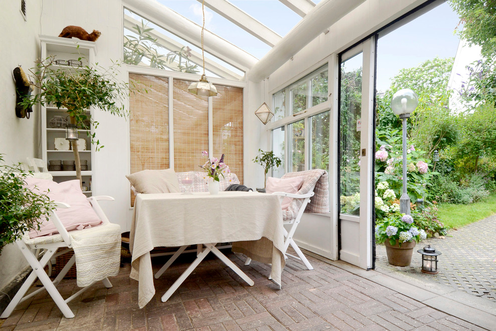 This is an example of a scandi conservatory in Aarhus with a glass ceiling and brown floors.
