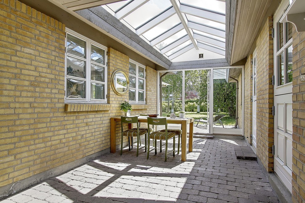 Стильный дизайн: терраса среднего размера с кирпичным полом и стеклянным потолком без камина - последний тренд