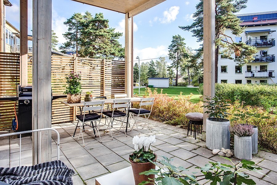 Стильный дизайн: двор среднего размера на заднем дворе в скандинавском стиле с летней кухней, покрытием из бетонных плит и навесом - последний тренд